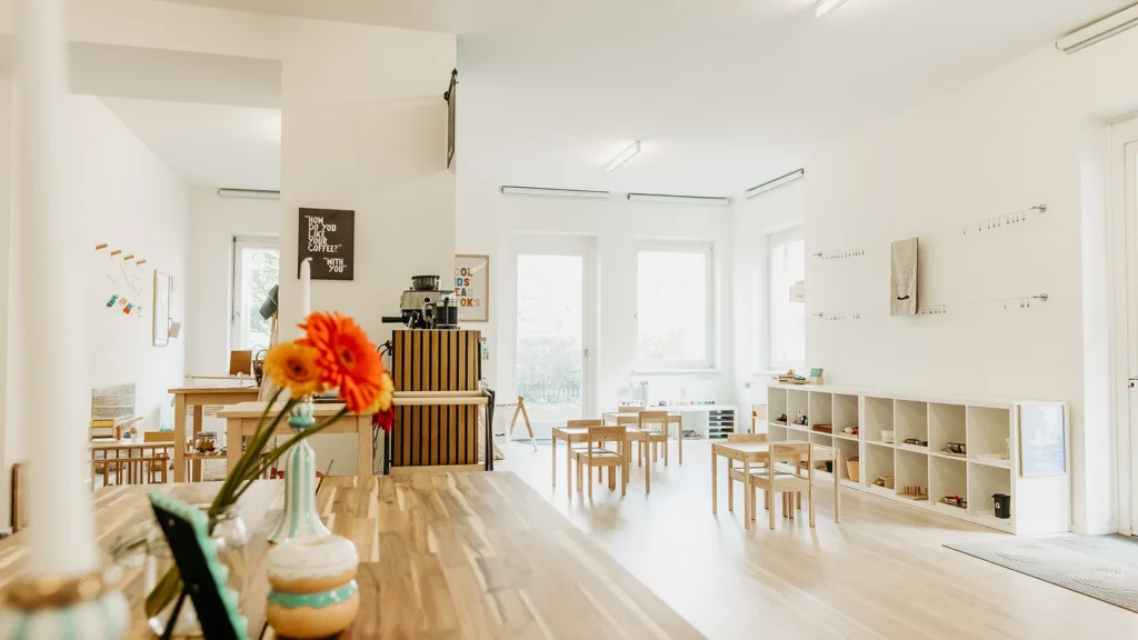A warm, inviting Montessori space at The Babyccino Club family cafe in Graz, featuring children's play areas and natural learning materials.